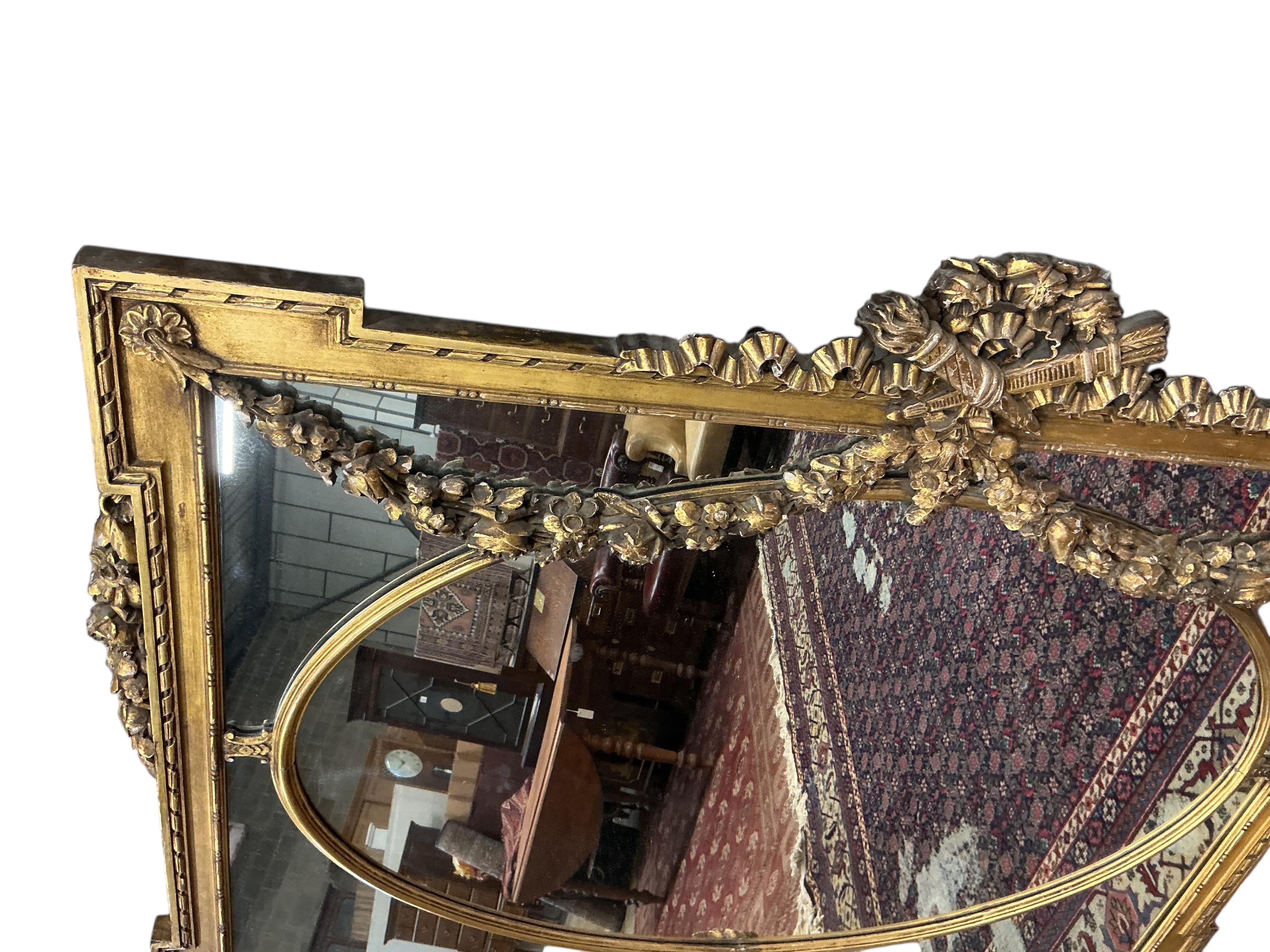 A Victorian style giltwood and composition overmantel mirror with cross torch and quiver crest, width 136cm, height 110cm